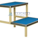 Hospital double step foot stool with blue anti-slip treads edged in stainless steel trim on a cream powder-coated square steel frame
