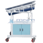 Baby cot with clear acrylic crib tilted on a white frame above a two door cabinet with light blue doors and four castors