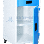 Hospital bedside locker with stainless steel top, blue drawer with recessed handle and the cupboard door open showing an internal shelf, on four castors