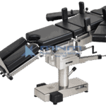 Operating table with black upholstered multi section top, shoulder supports, arm boards and leg troughs fitted, on a low rectangular stainless base with foot pedals