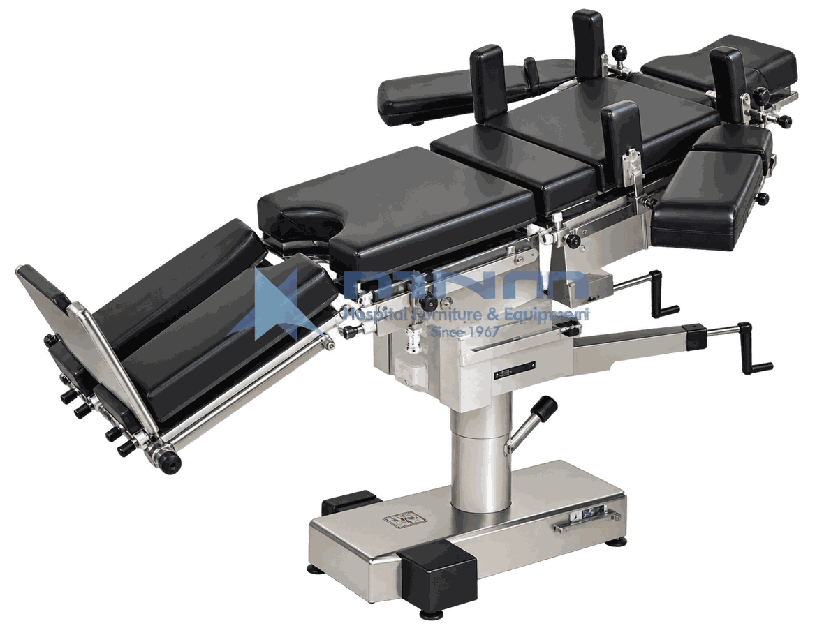 Operating Table with Foot Pedal Base and Full Accessory Set Operating table with black upholstered multi section top, shoulder supports, arm boards and leg troughs fitted, on a low rectangular stainless base with foot pedals