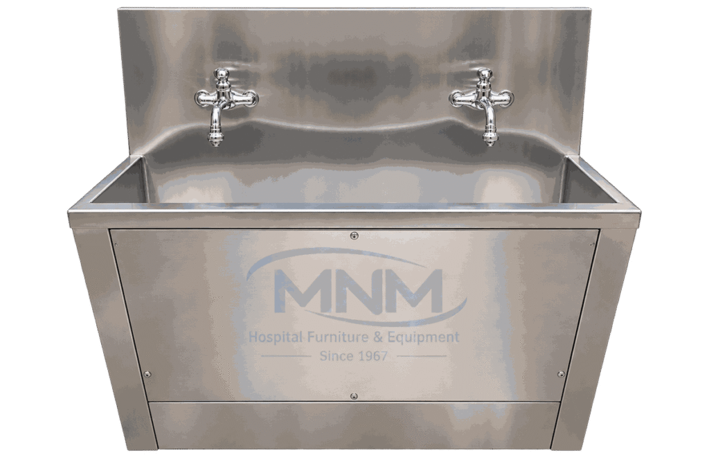 Stainless steel two station scrub sink with a single long trough, two chrome cross-handle taps on the backsplash and a panelled apron